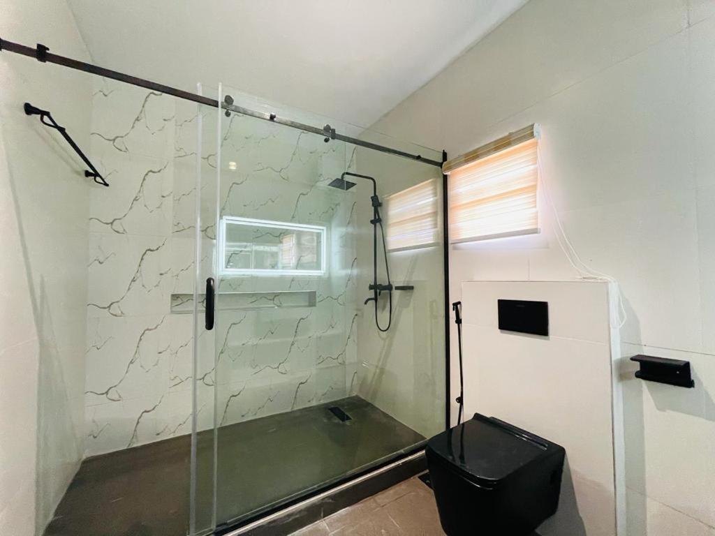 a bathroom with a glass shower with a toilet at Casa in Abuja