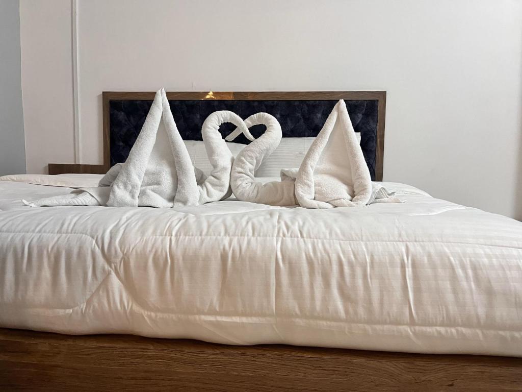 uma cama branca com almofadas brancas de cisne em SM LODGE and RESTAURANT em Guwahati