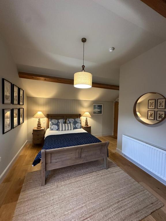 a bedroom with a large bed and a mirror at The Red Lion Inn Alnmouth in Alnmouth
