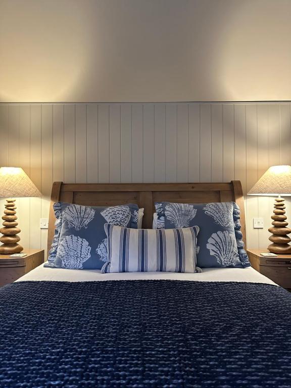 a bedroom with a bed with blue and white pillows at The Red Lion Inn Alnmouth in Alnmouth