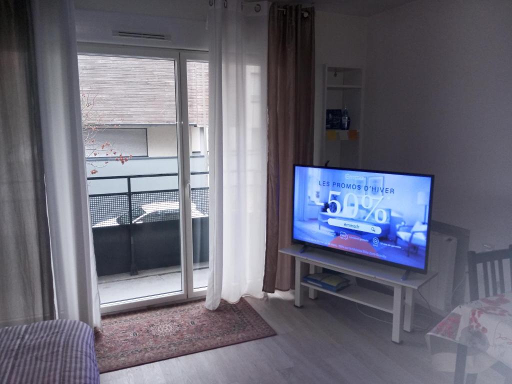 un salon avec une télévision et une fenêtre dans l'établissement T2 idéal étudiant + pro + parking protégé sous-sol, à Thouaré-sur-Loire