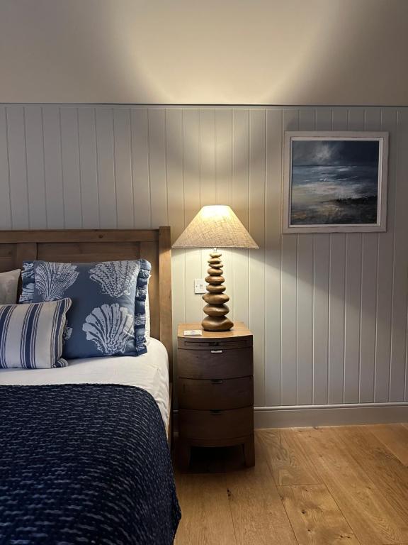 a bedroom with a bed and a lamp on a nightstand at The Red Lion Inn Alnmouth in Alnmouth