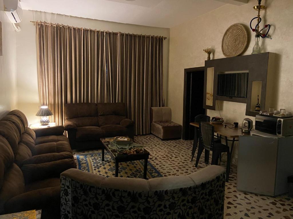 uma sala de estar com um sofá e uma mesa em Madaba Mesha Stele Bedoiun Apartments em Madaba