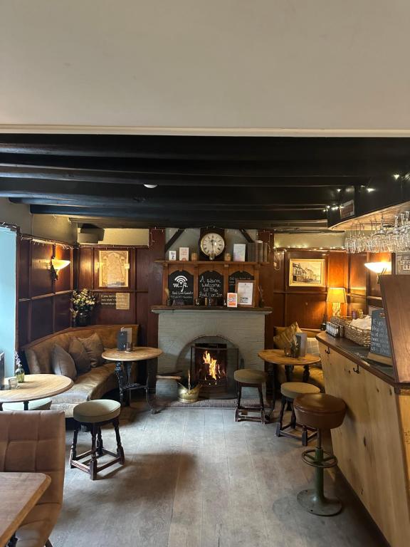 a restaurant with a fireplace and tables and a couch at The Red Lion Inn Alnmouth in Alnmouth