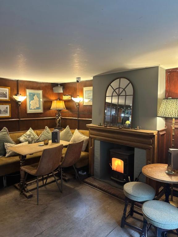 a living room with a fireplace and a table and chairs at The Red Lion Inn Alnmouth in Alnmouth