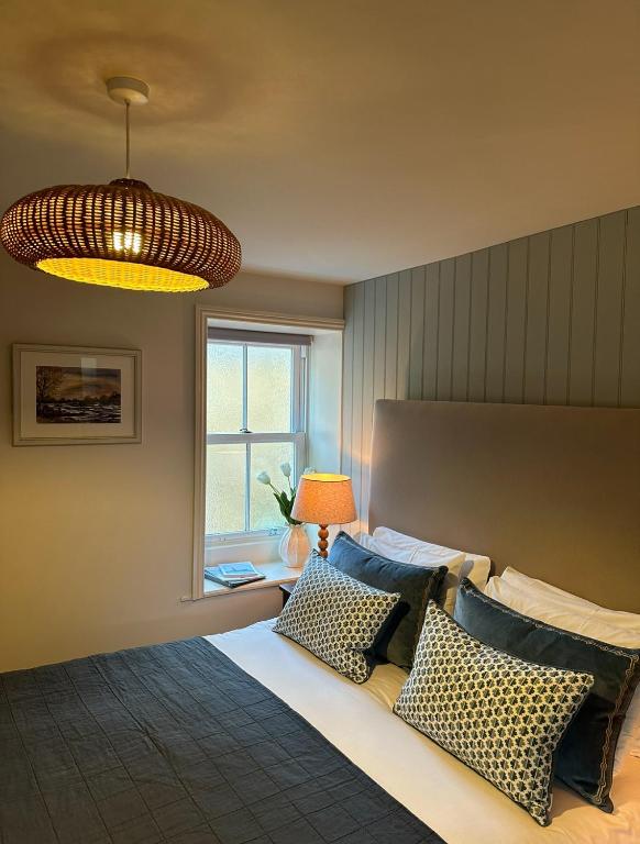 a bedroom with a bed with pillows and a window at The Red Lion Inn Alnmouth in Alnmouth