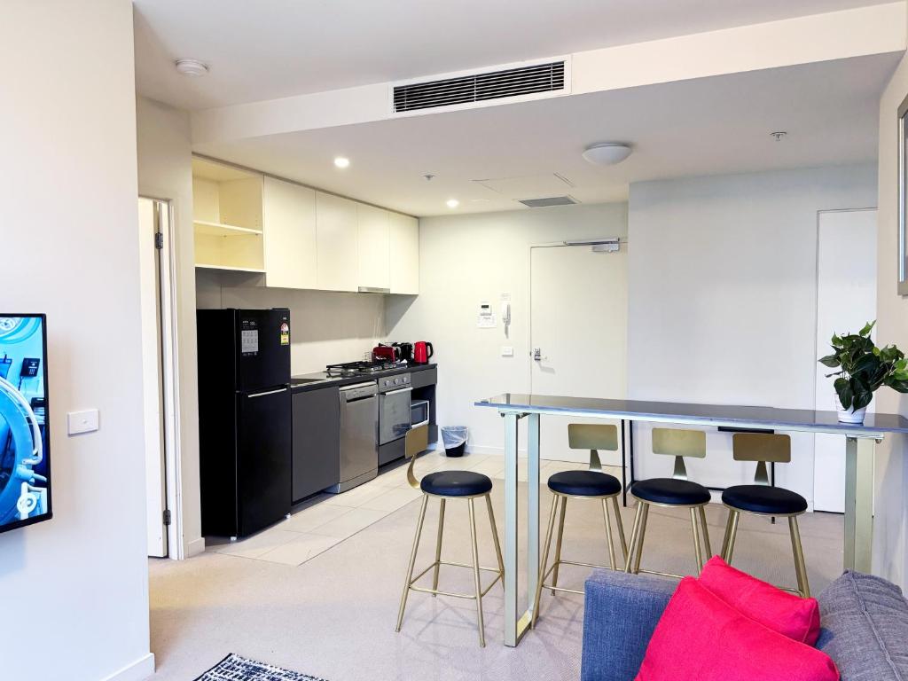 a kitchen with a table and stools in a room at Collins Serviced Apartments in Melbourne