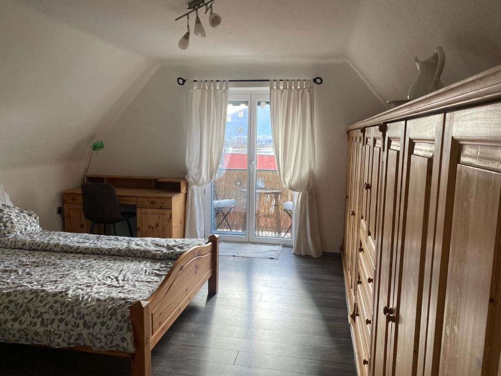 um quarto com uma cama e uma porta de vidro deslizante em Schönes Apartment mit Aussicht über Graz em Graz