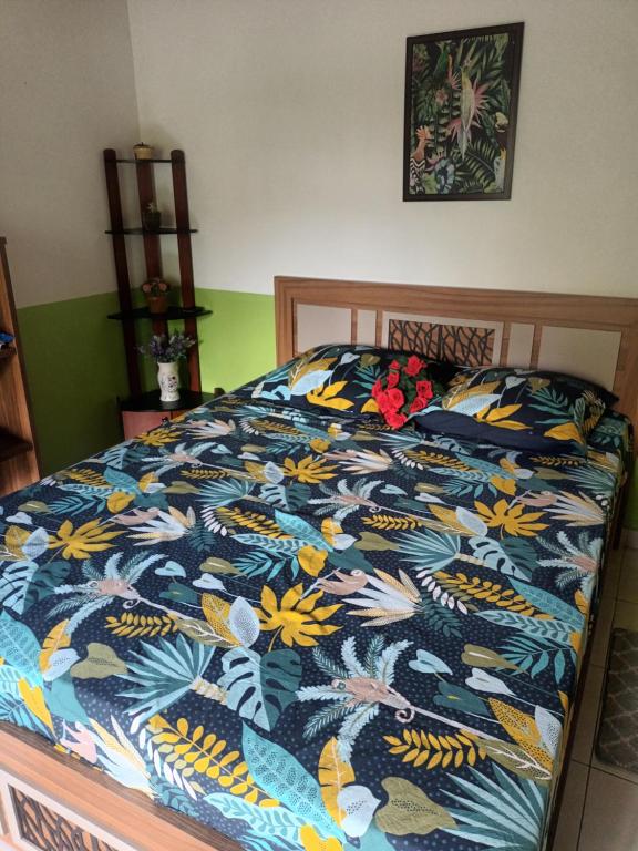 a bed with a colorful comforter with flowers on it at Lovely FLowers in Mount Lavinia in Mount Lavinia