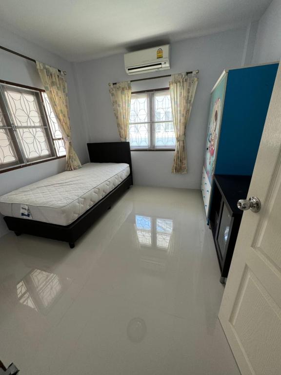 een slaapkamer met een bed, een tv en ramen bij บ้านมณียา in Noen Kra Prauk