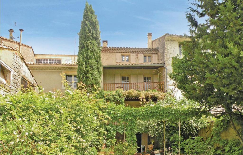 un grand bâtiment avec un arbre devant dans l'établissement Nice Home In St Didier With Kitchen, à Saint-Didier