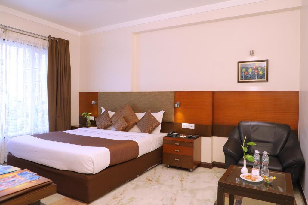 Habitación de hotel con cama grande y escritorio. en Amantra Comfort Hotel, en Udaipur
