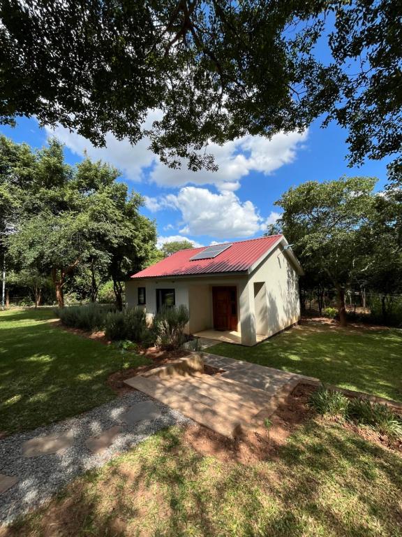 una pequeña casa blanca con techo rojo en Golden Bean Grove, en Lusaka