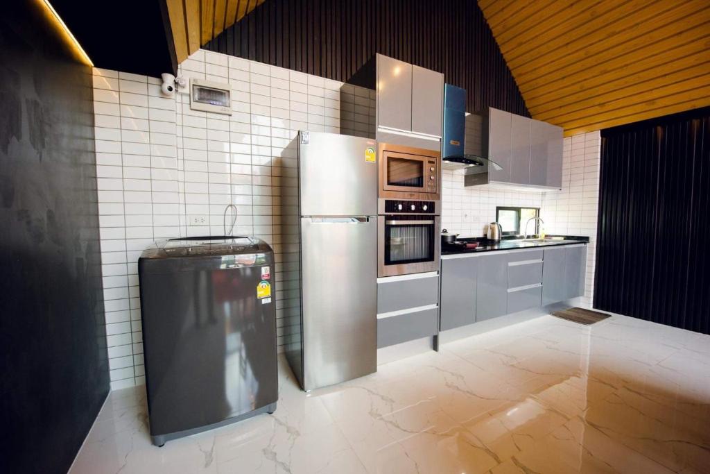 a kitchen with a stainless steel refrigerator in a room at NP Pool Villa Hua Hin in Hua Hin