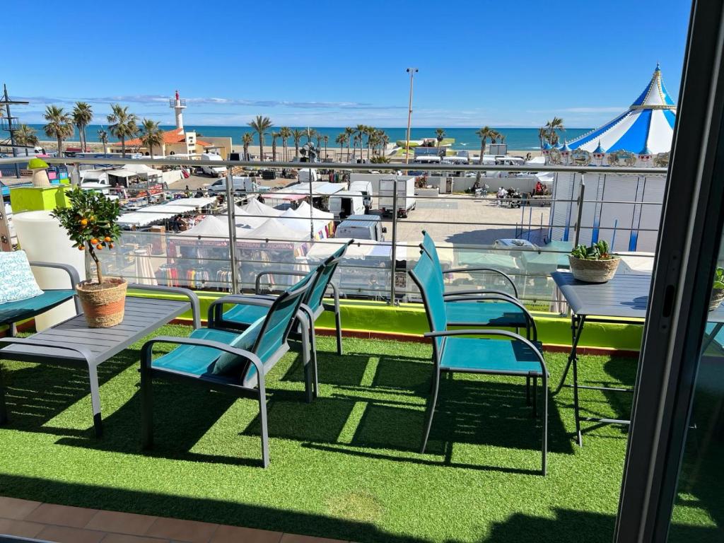 a balcony with chairs and tables and a view of a marina at Rivage in Le Barcarès