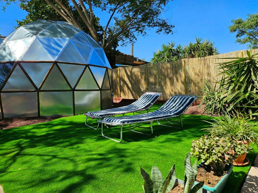 two lawn chairs and a tent in a yard at Finca AveStruz Noche mágica bajo las estrellas in San Isidro