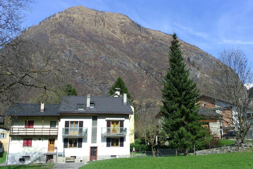 una casa blanca frente a una montaña en Appartement Casa Rancurina, en Olivone