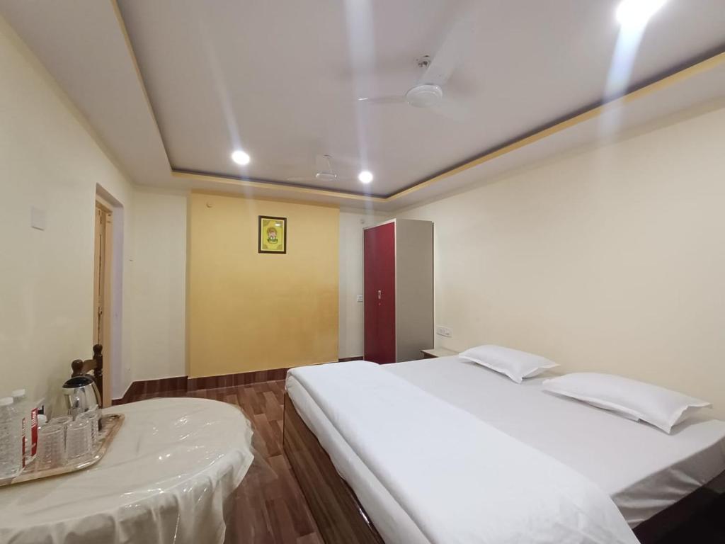 Un dormitorio con una gran cama blanca y una mesa en Luxury Homestay en Varanasi
