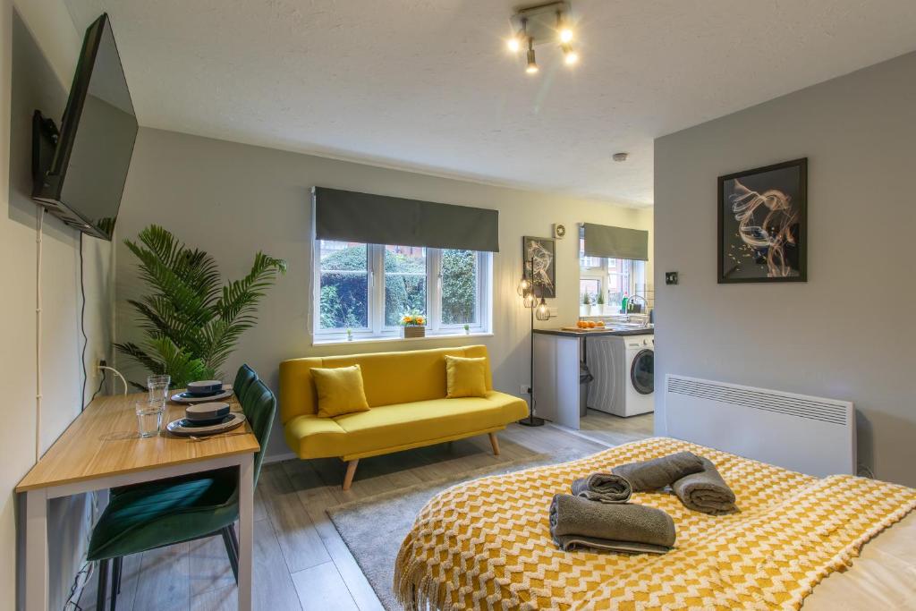 a bedroom with a bed and a yellow couch at Open Mind Property - City Centre & Free Parking in Southampton