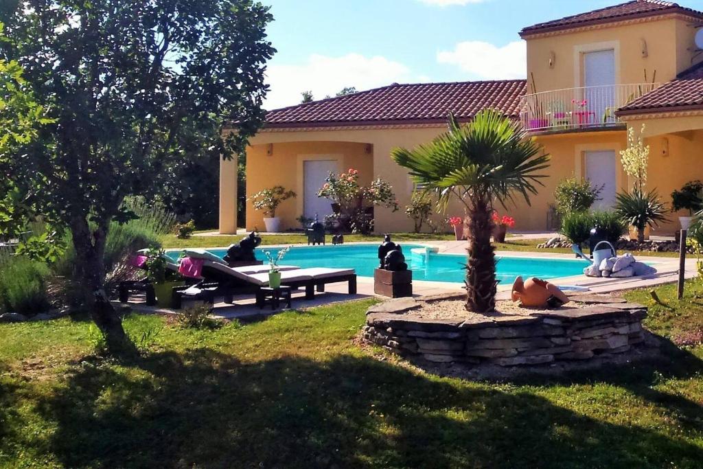 a group of people sitting by a swimming pool at Villa de 2 chambres avec piscine privee terrasse et wifi a Lalbenque in Lalbenque