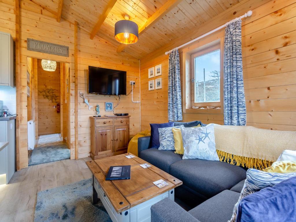a living room with a couch and a table at Seashell Lodge in Gairloch