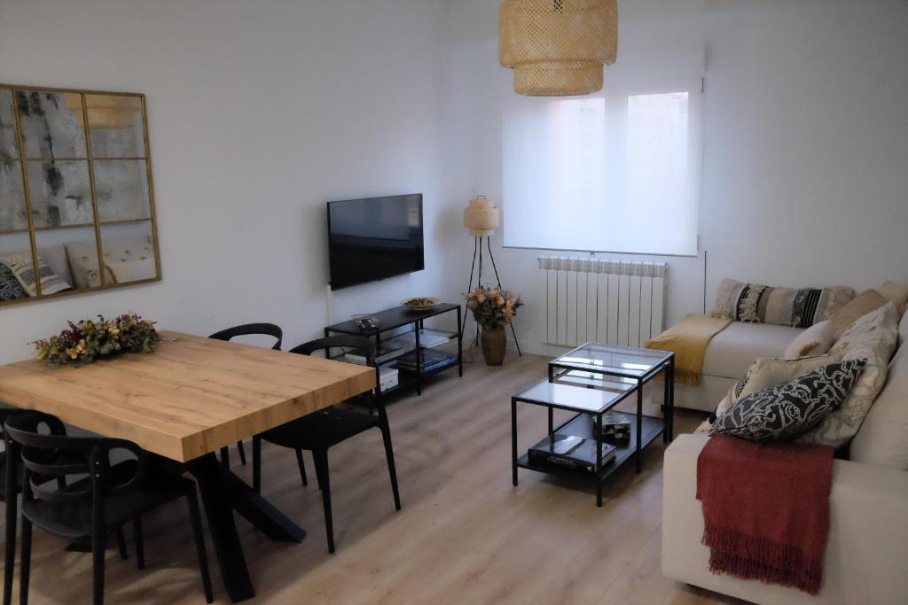uma sala de estar com uma mesa e um sofá em Capricho Lostal em Zaragoza