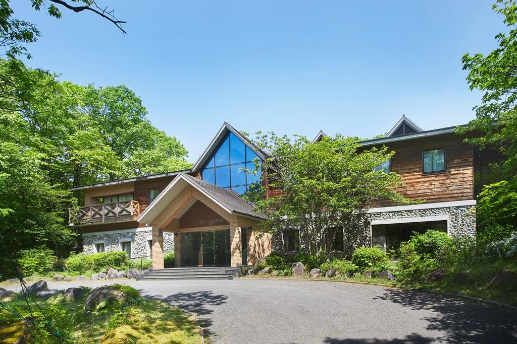 a house with a gambrel roof and a driveway at Shiki Resort Belufore Nasu in Nasu