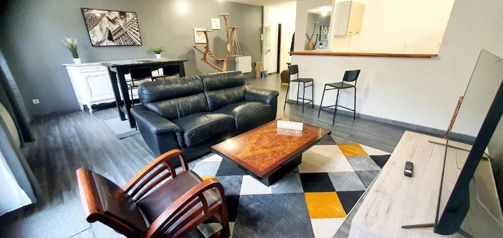un salon avec un canapé en cuir et une table dans l'établissement The Family - Bel Appartement 4/6 places, à Rouen