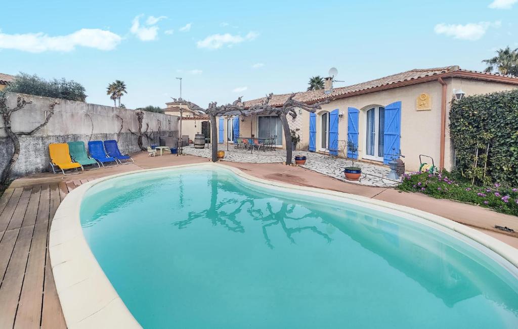 una piscina con sillas azules y una casa en 3 Bedroom Lovely Home In Caux, en Caux