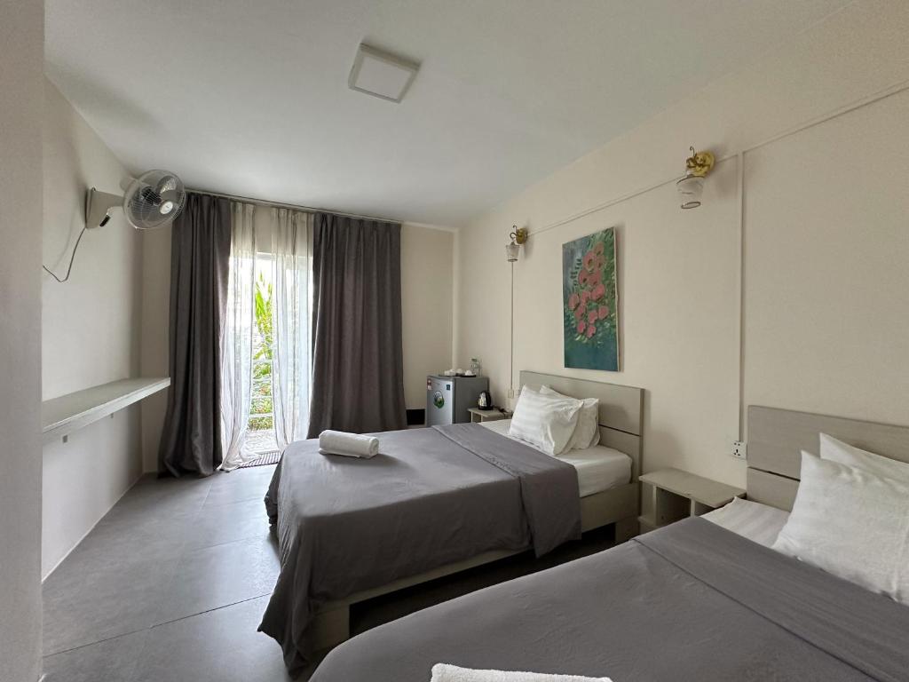 um quarto de hotel com duas camas e uma janela em Ginger Sihanoukville em Sihanoukville