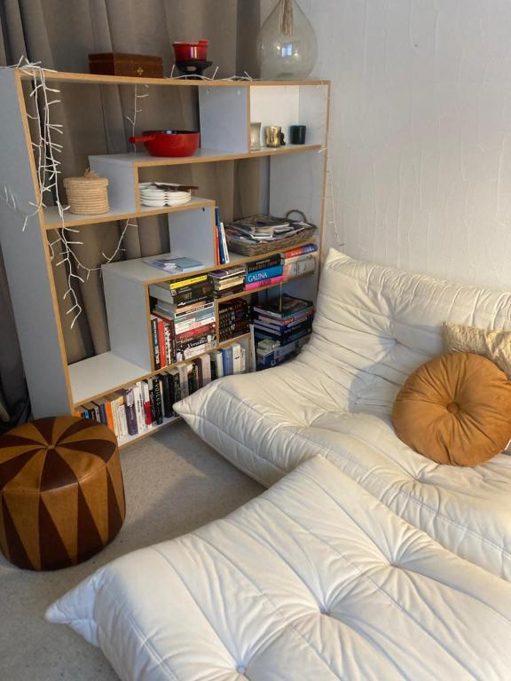 białe łóżko w pokoju z półką na książki w obiekcie Studio Swiss me up! w mieście Pontresina