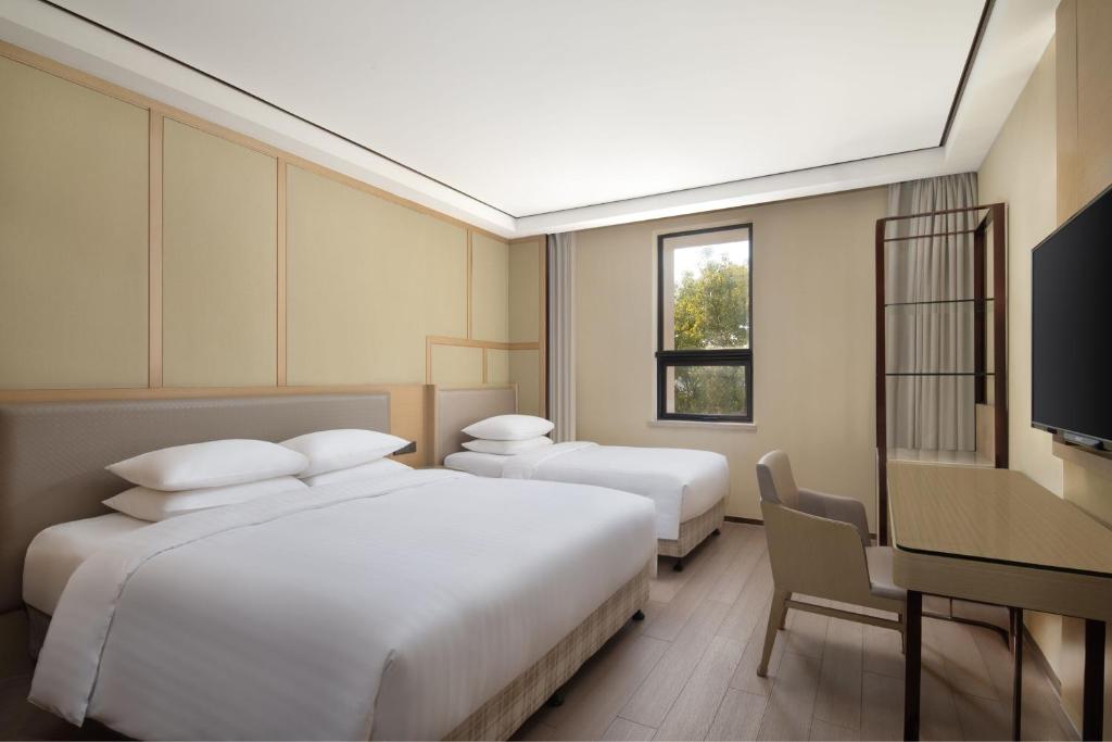 Postel nebo postele na pokoji v ubytování Courtyard by Marriott Shanghai International Tourism and Resorts Zone
