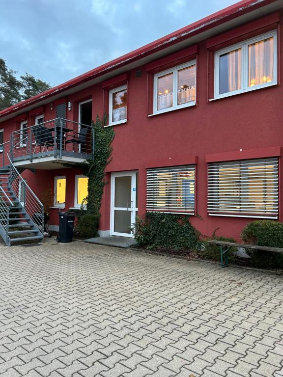 ein rotes Gebäude mit einer Seitentreppe in der Unterkunft Apartment Roth in Roth