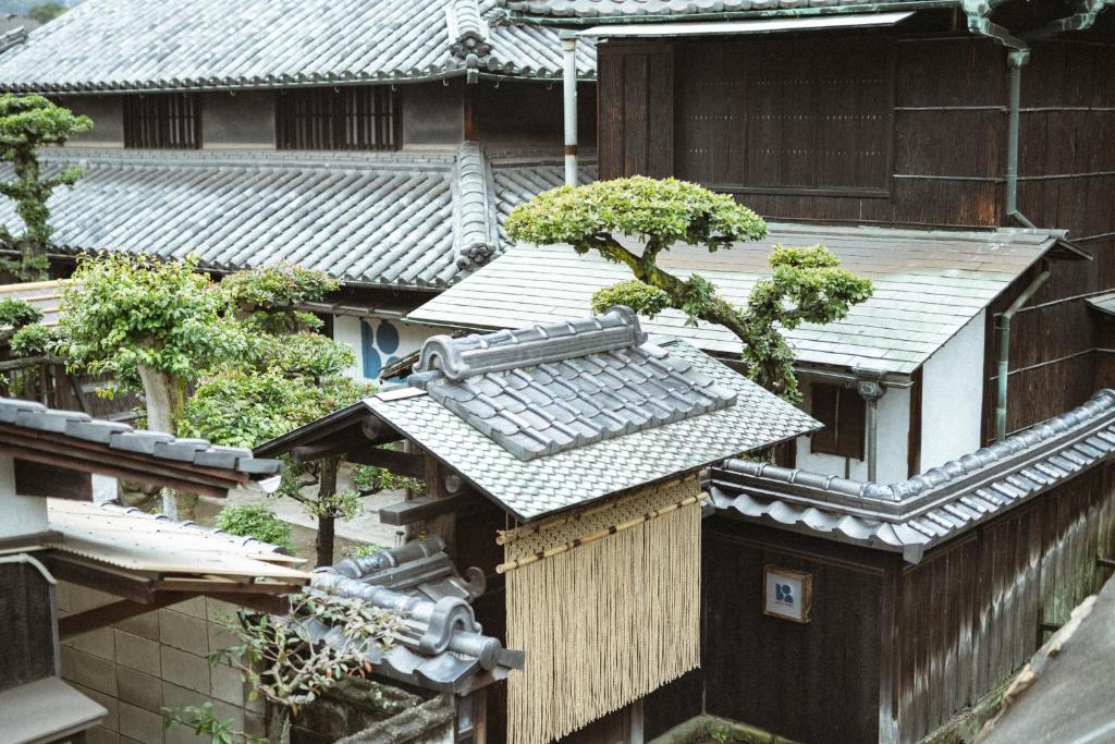 Um edifício asiático com uma árvore em cima. em DENIM HOUSE BON em Kurashiki