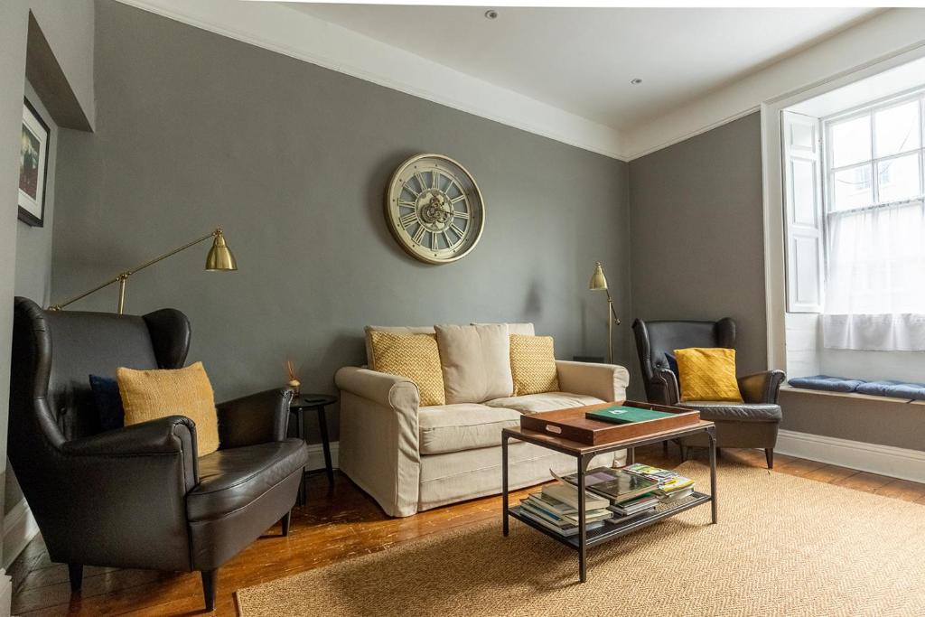 a living room with a couch and chairs and a clock at DUNDAS COTTAGE - Beautiful Spacious 3 Bed Cottage in Richmond, North Yorkshire in Richmond