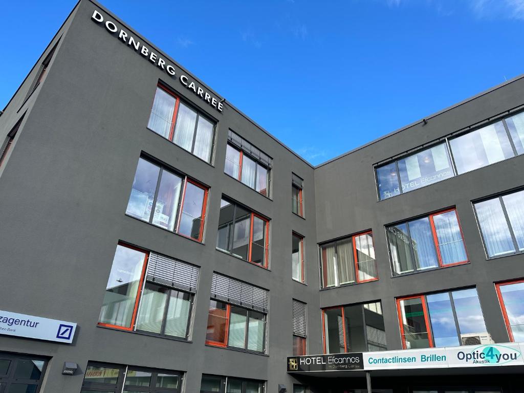 un edificio gris con un cartel en el costado en Hotel Efcannos Dornberg Carree en Vechelde