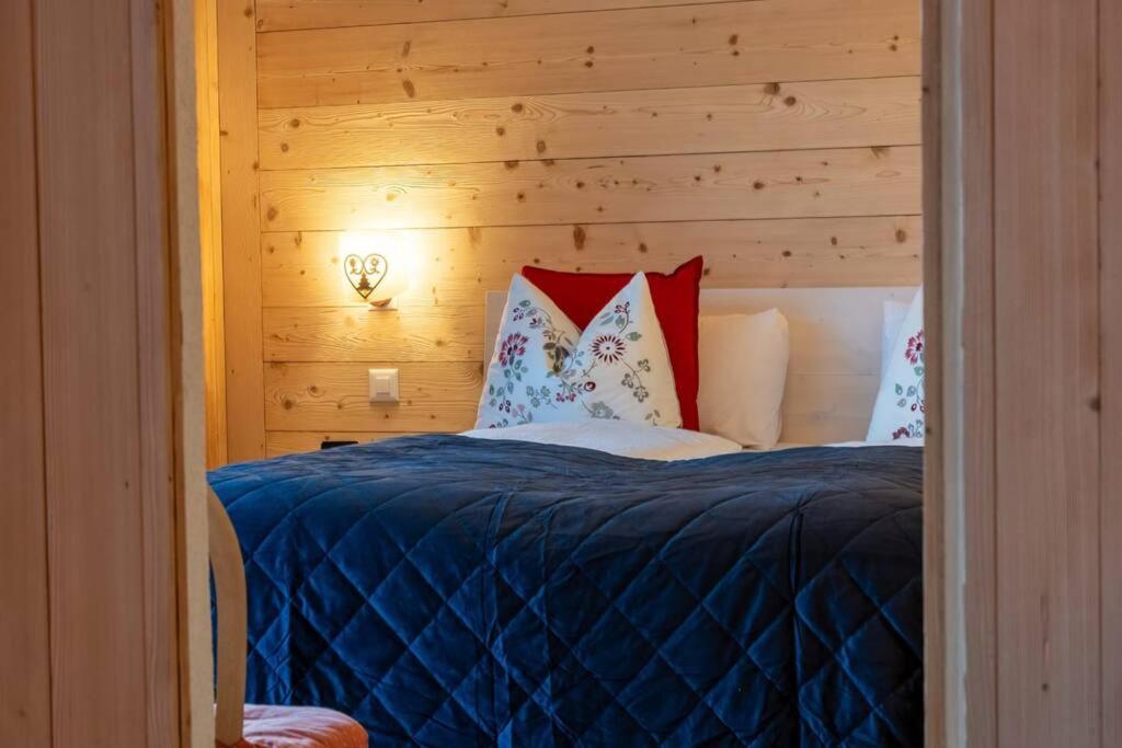 1 dormitorio con 1 cama con pared de madera en Fresh & Simple near Gstaad, en Gstaad