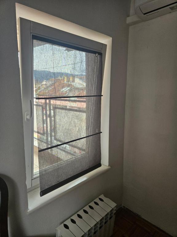 - une fenêtre dans une pièce avec un store dans l'établissement Apartman Ellye, à Lukavica