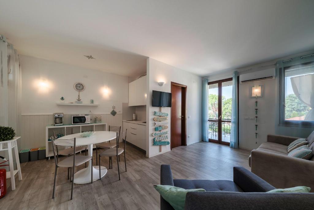 a living room with a couch and a table and a kitchen at Moretto 10 - con piscina e WiFi in Sirmione