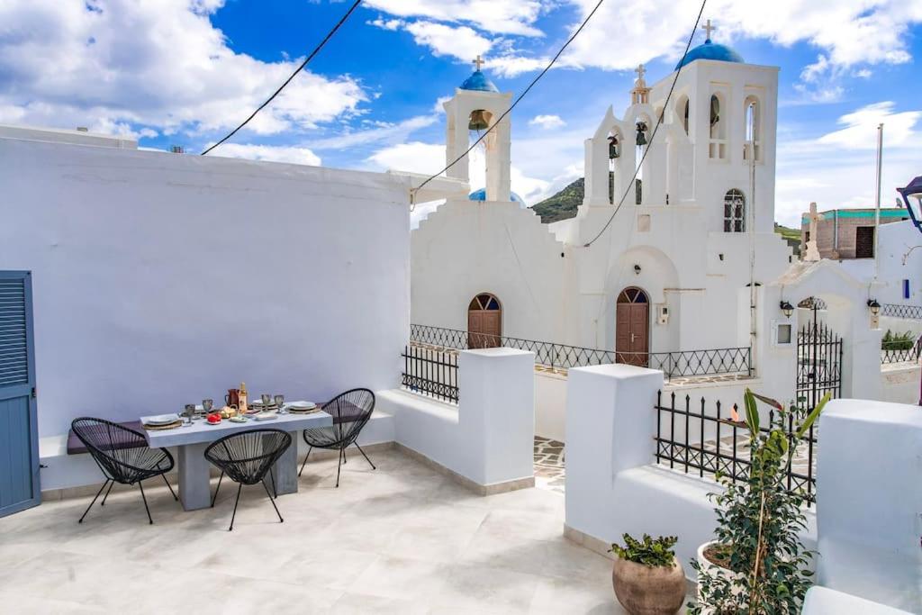 a patio with a table and chairs in front of a church at ElizabethHouse in Mármara