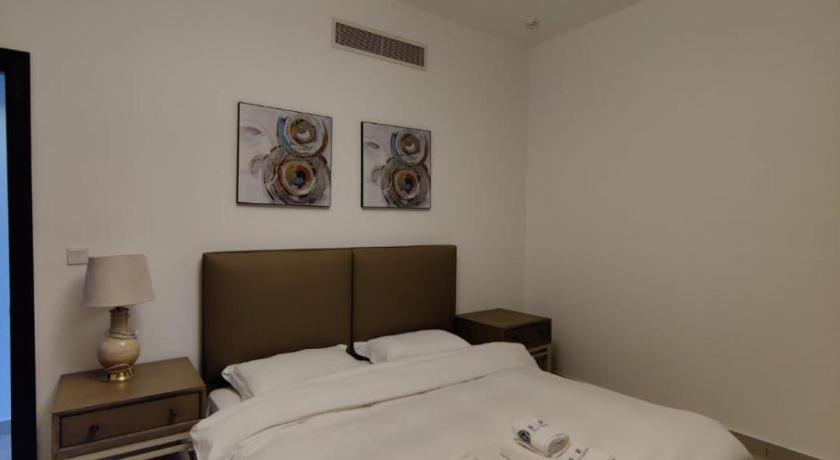 a bedroom with a bed and three pictures on the wall at Holiday Room in Dubai