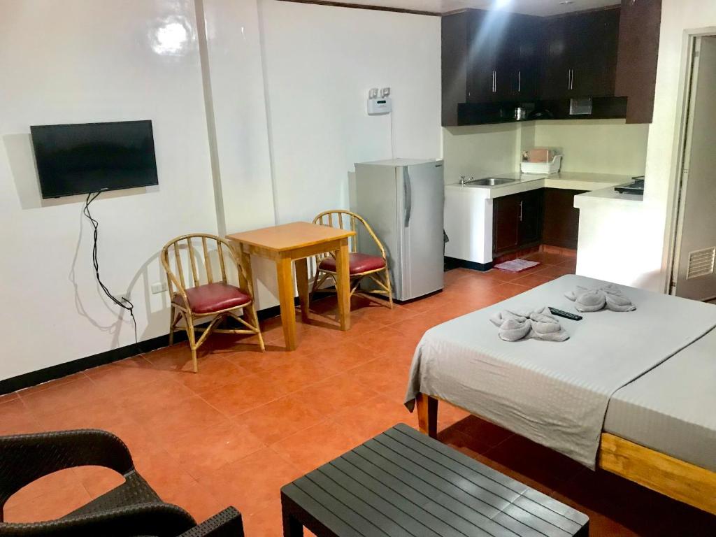 プエルト・ガレラにあるBadladz Staycation Condosのテーブルとキッチン付きの小さな部屋