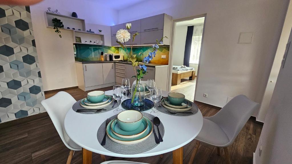 een witte eettafel met stoelen en een keuken bij Menta Holiday Home in Badacsonytomaj