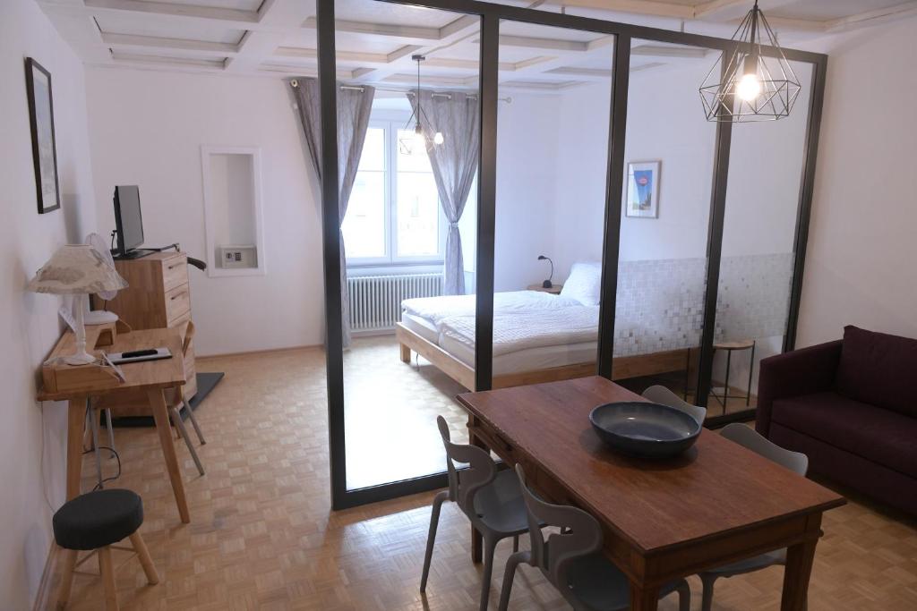 a living room with a table and a bed and a room at Albergo Diffuso Porrentruy in Porrentruy