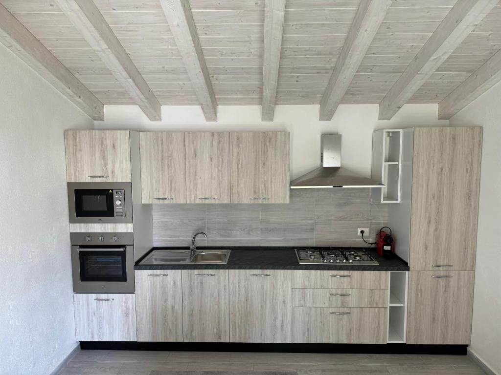 a kitchen with wooden cabinets and a black counter top at Villetta 3 La Caletta in La Caletta