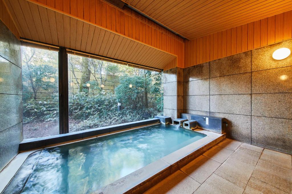 a swimming pool in a house with a large window at Shiki Resort Hakone Wanoka in Hakone