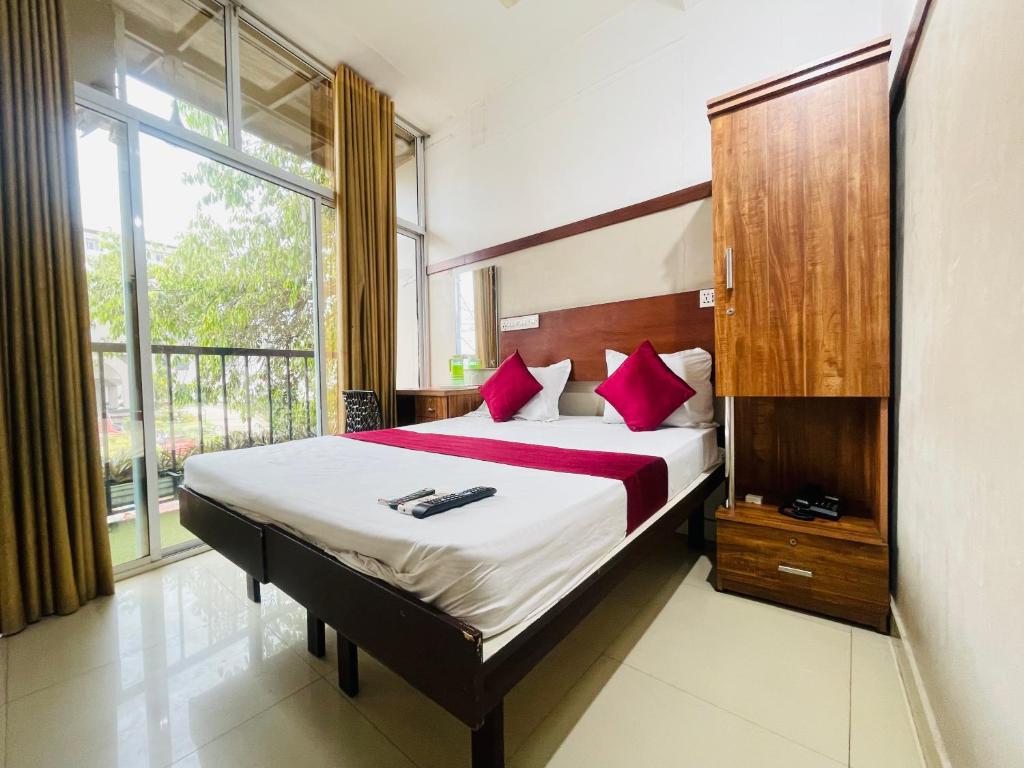 a bedroom with a large bed with red pillows at RIO ROOMS MIMS in Kozhikode