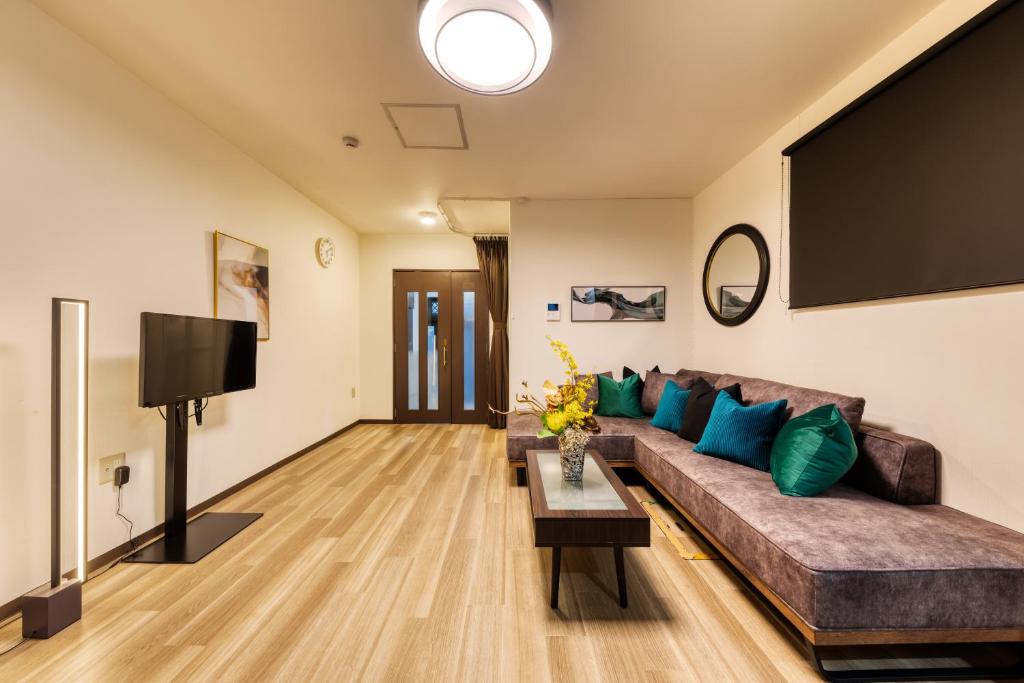 een woonkamer met een bank en een flatscreen-tv bij soleil Universal Fukushima Noda -vacation rental- in Osaka