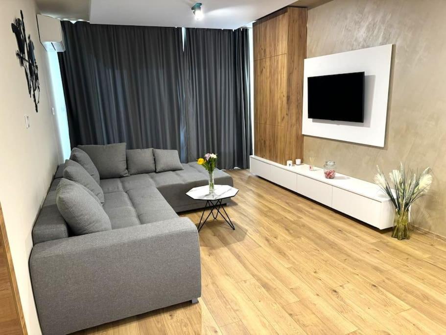 een woonkamer met een bank en een tv bij Cozy and Stylish Apartament in Stara Zagora