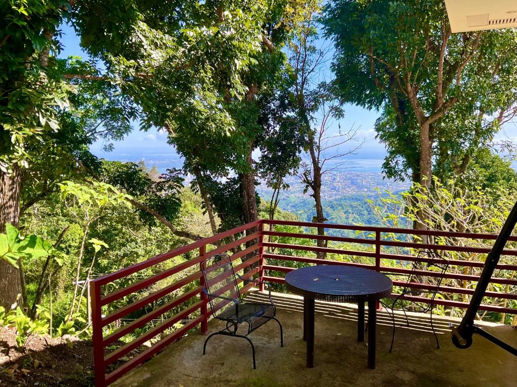 una mesa y una silla en un balcón con vistas en Aguanga Cabin at Threesome Cafe en Cebú